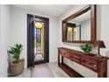 Inviting foyer with a stylish console table, decorative mirror, and an attractive view to the exterior at 27478 W Tonopah Dr, Buckeye, AZ 85396