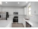 Modern kitchen with stainless steel appliances, white cabinets, and subway tile backsplash at 9042 N 116Th Ln, Youngtown, AZ 85363