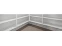Spacious walk-in pantry with ample shelving and tile flooring for organized storage at 9042 N 116Th Ln, Youngtown, AZ 85363