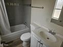 Bathroom includes a tub, toilet, vanity, and gray tile at 6623 S 23Rd Pl, Phoenix, AZ 85042