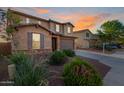 Beautiful stucco home featuring a two-car garage, with stone accents and desert landscaping at 4102 S 186Th Ave, Goodyear, AZ 85338
