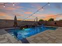 Sparkling pool and spa in this backyard oasis, complete with waterfall feature and string lights at 4102 S 186Th Ave, Goodyear, AZ 85338