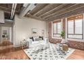 Bright living room features concrete ceilings, brick accents, hardwood floors and large windows with woven shades at 114 W Adams St # 506, Phoenix, AZ 85003