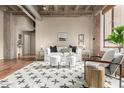 Bright living room with a concrete ceiling, hardwood floors, and exposed brick, offering a modern aesthetic at 114 W Adams St # 506, Phoenix, AZ 85003