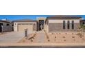 Beautiful home exterior with stone accents, well-kept yard, complemented by a spacious two-car garage at 23978 S 218Th Pl, Queen Creek, AZ 85142