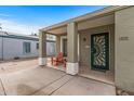 Charming covered front porch with seating and decorative green door at 1325 E Monte Vista E Rd, Phoenix, AZ 85006