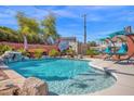 Backyard pool featuring a rock waterfall, poolside lounging area, and shimmering blue water on a sunny day at 1820 N 7Th Ave, Phoenix, AZ 85007