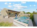 Backyard oasis featuring a pool, spa, and outdoor kitchen with a seating area at 3125 N 86Th Pl, Scottsdale, AZ 85251