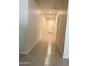 Bright hallway featuring tile flooring and neutral paint, leading to the front door at 24569 W Whyman Ave, Buckeye, AZ 85326