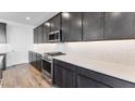 Modern kitchen featuring stainless steel appliances, dark cabinets, and white subway tile backsplash at 3804 S Buttercup --, Mesa, AZ 85212
