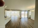 Spacious living room with wood-look tile flooring, recessed lighting, and sliding glass doors to patio at 3804 S Buttercup --, Mesa, AZ 85212