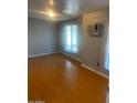 Comfortable bedroom with wood floors and a large window providing natural light at 1302 W Estrella Dr, Chandler, AZ 85224