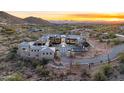 Stunning aerial view of estate home at sunset with mountain views and desert landscaping at 10739 E Diamond Rim Dr, Scottsdale, AZ 85255