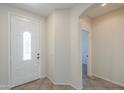 Bright front foyer features neutral colors and tile flooring with a glass accented front door at 43594 W Bravo Ct, Maricopa, AZ 85138