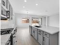 Bright, modern kitchen with stainless steel appliances, large island, and sleek gray cabinetry at 5845 S Romano --, Mesa, AZ 85212