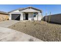 Attractive home exterior with a gravel front yard and young trees, showcasing modern design at 16062 W Prickly Pear Trl, Surprise, AZ 85387