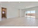 Bright, open living room with light tile floors, recessed lighting, and sliding glass doors to the backyard at 25153 N 177Th Dr, Surprise, AZ 85387