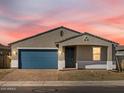 Beautiful home with a blue garage door and modern gray exterior under a stunning pink sky at 4832 N 177Th Dr, Goodyear, AZ 85395