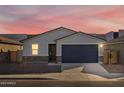 One-story home with gray siding, a dark gray garage door, and stone accents at 9121 N 173Rd Ln, Waddell, AZ 85355