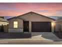 Tan house with brown garage door at sunset at 9127 N 173Rd Ln, Waddell, AZ 85355