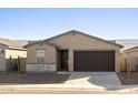 Tan house with brown garage door and stone accents at 9127 N 173Rd Ln, Waddell, AZ 85355