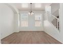 Bright dining area features hardwood floors, arched entryway and a modern chandelier at 14862 W Laurel Ln, Surprise, AZ 85379