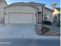 Tan one-story house with a two-car garage and desert landscaping at 805 W Sunset Dr, Coolidge, AZ 85128