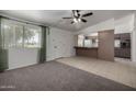 Living room with carpet flooring and a view of the kitchen at 10434 W Oakmont Dr, Sun City, AZ 85351