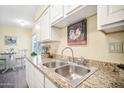 Kitchen features granite countertops and white cabinets at 10606 W Granada Dr, Sun City, AZ 85373