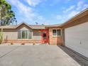 Charming single-story home with mature landscaping and a welcoming red front door at 8450 E Montecito Ave, Scottsdale, AZ 85251