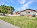 Charming single-story home with mature landscaping and a well-manicured lawn at 8450 E Montecito Ave, Scottsdale, AZ 85251