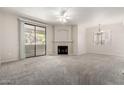 Spacious living room with plush carpeting, fireplace, and sliding glass doors to the patio at 15380 N 100Th St # 1106, Scottsdale, AZ 85260
