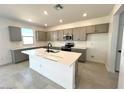 Modern kitchen features an island, stainless appliances, gray cabinets and ample counter space at 25204 W Wayland Dr, Buckeye, AZ 85326