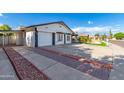 Stylish single-story home featuring a long driveway and a beautifully landscaped front yard at 5038 W Echo Ln, Glendale, AZ 85302