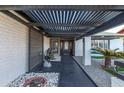Covered entry of a stylish home, showcasing modern accents and stone landscaping at 5038 W Echo Ln, Glendale, AZ 85302