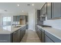 Modern kitchen with gray cabinets, quartz countertops and stainless steel appliances at 16367 W Morning Glory St, Goodyear, AZ 85338