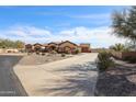 Wide view of the desert home exterior, highlighting the long driveway and three-car garage at 19517 W Huron Ln, Buckeye, AZ 85326