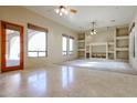 Bright living room featuring tile flooring, built-in shelving, and a large window at 19517 W Huron Ln, Buckeye, AZ 85326