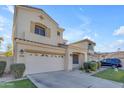 Two-story house with tan exterior, two-car garage, and landscaped yard at 2067 W Periwinkle Way, Chandler, AZ 85248