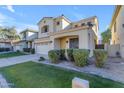 Two-story house with tan exterior, two-car garage, and landscaped yard at 2067 W Periwinkle Way, Chandler, AZ 85248