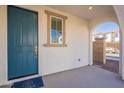 Inviting covered front porch features a stylish blue door, window, and neutral concrete flooring at 2200 N Iowa St, Chandler, AZ 85225