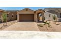 A quaint single-story home with a two-car garage, beautiful desert landscaping, and a paved driveway at 5656 N 205Th Ln, Buckeye, AZ 85396