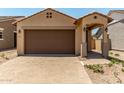Charming single-story home with a two-car garage, paved driveway, and low-maintenance desert landscaping at 5656 N 205Th Ln, Buckeye, AZ 85396