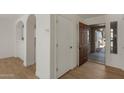 Welcoming entryway featuring wood floors, arched doorways, storage, and a view of the front door at 7035 W Rose Ln, Glendale, AZ 85303