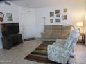 Cozy living room with a tan sofa, floral recliner, and wall decor at 1881 E Kerby Farms Rd, Chandler, AZ 85249
