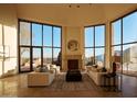 Bright living room with walls of windows and a fireplace, offering scenic views and natural light at 6020 E Indian Bend Rd, Paradise Valley, AZ 85253