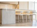 Kitchen island features a marble waterfall design, seating for four, and modern lighting at 2402 E Esplanade Ln # 601, Phoenix, AZ 85016