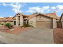 Tan colored stucco house with tile roof and attached garage at 9478 E Corrine Dr, Scottsdale, AZ 85260