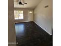 Bright living room with dark wood-look floors and updated ceiling fan at 5738 N 68Th Ave, Glendale, AZ 85303