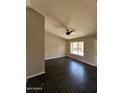 Bright living room featuring modern ceiling fan and dark wood-look floors at 5738 N 68Th Ave, Glendale, AZ 85303